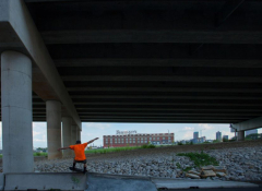 Young black child playing under an interstate